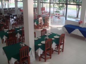 a dining room with green and white tables and chairs at Ruta Del Sol in Ypacarai