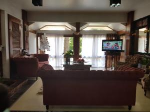 a living room with couches and a flat screen tv at Residencial Pousada do Serrano in Gramado
