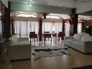 a living room with two white couches and a table at Residencial Pousada do Serrano in Gramado
