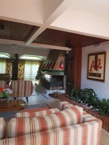 a living room with couches and a fireplace at Residencial Pousada do Serrano in Gramado