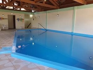 a large swimming pool with blue water in a room at Residencial Pousada do Serrano in Gramado