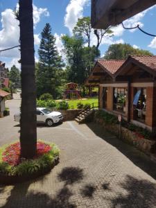 a car parked in front of a building with a playground at Residencial Pousada do Serrano in Gramado