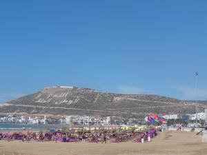 een strand met een stel stoelen en parasols bij Appartment Avenue Hassan II in Agadir