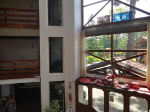 a teddy bear sitting on a window sill in a room at Residencial Pousada do Serrano in Gramado