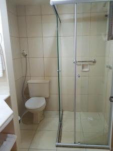 a bathroom with a toilet and a glass shower at Residencial Pousada do Serrano in Gramado