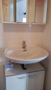 lavabo blanco en el baño con espejo en Baunaeck en Baunatal