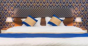 um quarto com uma cama com almofadas azuis e brancas em منازل الورد للشقق المخدومه Tabuk Risdance em Tabuk
