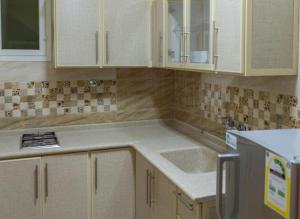 a kitchen with white cabinets and a sink at منازل الورد للشقق المخدومه Tabuk Risdance in Tabuk