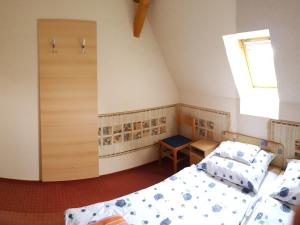 ジュラにあるKastélykert Apartmanのベッド2台と窓が備わる小さな客室です。