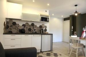 a kitchen with white cabinets and a microwave at Lespinet in Toulouse