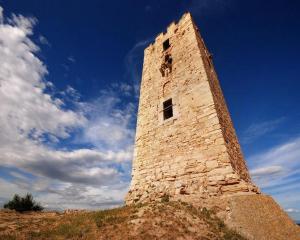 a tall stone tower on top of a hill at Kiwi Kastle in Nea Fokea