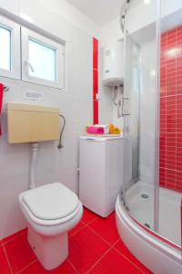 a bathroom with a white toilet and a shower at Apartment Jadrija in Šibenik