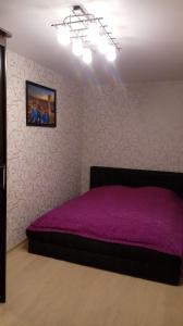 トヴェリにあるАпартаменты на Володарскогоのベッドルーム1室(紫色のベッド1台付)