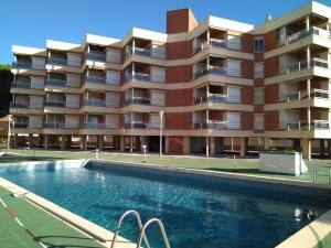 カンブリルスにあるApartamento Sol de Españaのアパートメントの建物の正面にスイミングプールがあります。