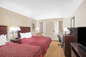 a hotel room with two beds and a flat screen tv at Days Inn by Wyndham Springfield/Phil.Intl Airport in Springfield +23 photos