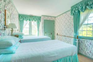 a bedroom with two beds and a window at Villa Victoria - Cozy Hamptons Villa in Bridgehampton +37 photos