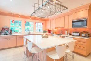 a large kitchen with a large white table and chairs at Villa Victoria - Cozy Hamptons Villa in Bridgehampton