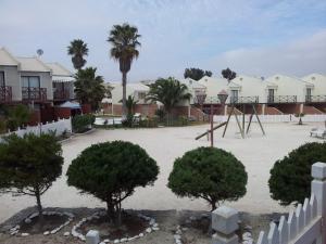 un parco con parco giochi e alberi e case di Bahia Inglesa Apartamentos a Bahia Inglesa