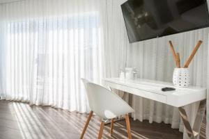 a white desk with a white chair next to a window at President Hotel in Miami Beach