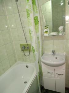 a bathroom with a sink and a tub and a sink and a sink at Apartment in the center of old town in Kamianets-Podilskyi