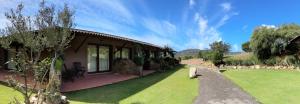 a house with a green lawn in front of it at Hotel Spartivento in Chia