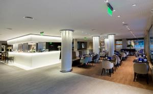 a restaurant with tables and chairs and a bar at Windsor Hotel in Córdoba