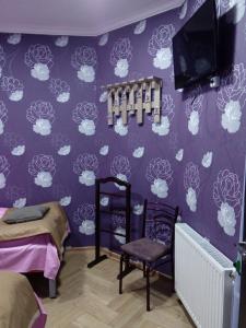 Un dormitorio con una pared púrpura con tazas blancas en Tbilisi Downtown Guest House, en Tiflis