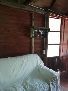 una camera da letto con un letto bianco con una finestra di Cabañas Lagos Dos Molinos a Marcos Paz