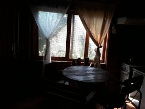 una stanza buia con un tavolo davanti a una finestra di Cabañas Lagos Dos Molinos a Marcos Paz