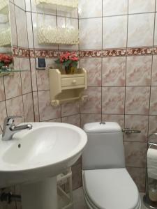 a bathroom with a white sink and a toilet at Pokoje U Eli in Brzegi