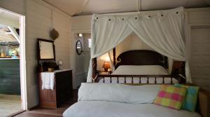- une chambre avec un lit à baldaquin dans l'établissement Bungalow Karaib Lodge, à Saint-François