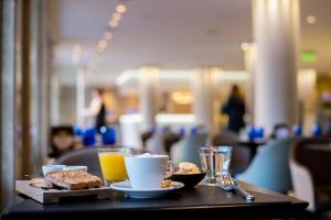 a table with a plate of food and a cup of coffee at Windsor Hotel in Córdoba