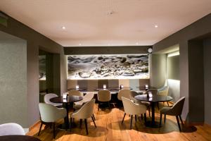 a dining room with tables and chairs and a painting on the wall at Windsor Hotel in Córdoba