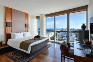 a hotel room with a bed and a desk and windows at The Setai, Miami Beach in Miami Beach