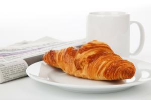 a croissant on a plate next to a coffee cup at Castle House Inn in Stockholm