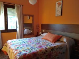 a bedroom with a bed with a colorful blanket at Casa Rural El Cabo in Carucedo
