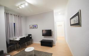 a living room with a table and a tv on a wall at Alcam Valencia II in Barcelona