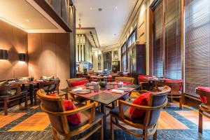 a restaurant with wooden tables and chairs and a large window at The Setai, Miami Beach in Miami Beach