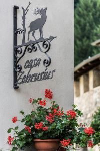 una señal en el lado de un edificio con flores en Casa Zebrusius - Bepi&Piera's Suite en Valfurva