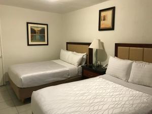 a hotel room with two beds and a lamp at Hotel Guillen Jr in Tijuana
