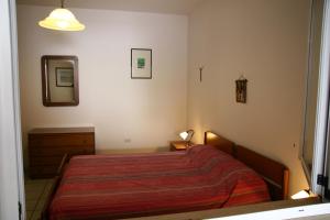 トッレ・サン・ジョヴァンニ・ウジェントにあるvillino Elisa mare verdeのベッドルーム1室(赤い毛布と鏡付きのベッド1台付)
