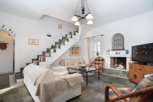 a living room with a white couch and a staircase at Helen villa Paros in Ekatondapilianí