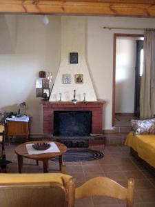 een woonkamer met een open haard en een tafel bij Traditional stone house with beautiful garden in Ayía Sofía