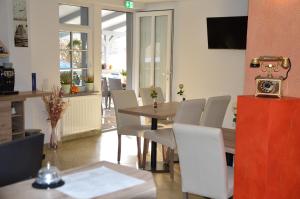 a dining room with a wooden table and white chairs at Hotel Mezzero in Waldshut-Tiengen