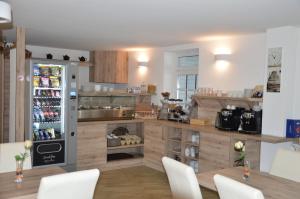 a kitchen with a refrigerator and a table and chairs at Hotel Mezzero in Waldshut-Tiengen