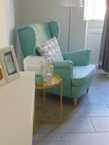 ein Wohnzimmer mit einem blauen Stuhl und einem Tisch in der Unterkunft Lost In Florence in Florenz