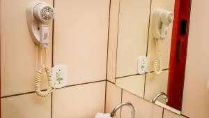 łazienka z dwoma telefonami wiszącymi na ścianie w obiekcie Hotel Winner w mieście Barretos