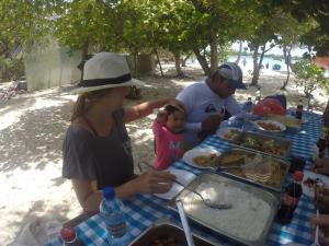 a group of people sitting at a table eating food at Acqua Blu Rasdhoo in Rasdhoo