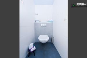 Un baño con un inodoro blanco en una cabina. en Amsterdam Farmland, en Ámsterdam 24 fotos más