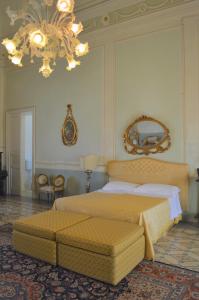1 dormitorio con cama y lámpara de araña en Palazzo Vecchio, en Marittima